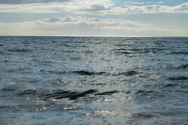 Deniz soyut ya da dalgalı su dokusu arka planı. Su yüzeyinin dokusunu su sıçramaları ve dalgalarla sakinleştir. Soyut doğa geçmişi. Mavi okyanus suyunun yüzeyi