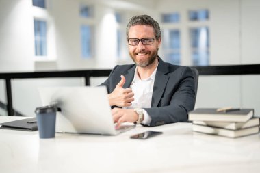 Modern ofis. İşletme takımında başarılı bir beyaz iş adamı dizüstü bilgisayar kullanıyor, uzaktan kumandayla çalışıyor, e-ticaret yapıyor. Finans denetçisi. Yönetim kurulu başkanının iş fikri var. İş dünyası