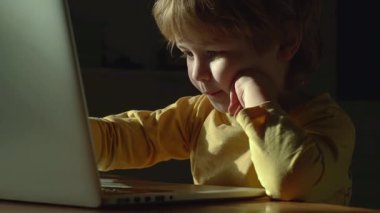 Bilgisayarlı bebek. Evde dizüstü bilgisayarla çalışan sarışın bir bebek. Akıllı küçük çocuk dizüstü bilgisayarını kullanıyor. Sevimli bebek bilgisayarı. Bilgisayardaki küçük kız. Bir dizüstü bilgisayarın önünde bebek şaşırmış ifadesi