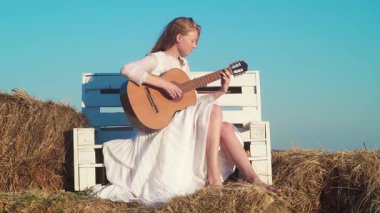 Gitar çalan kız. Gitarlı romantik bir kadın. Açık havada güzel bir şarkıcı. Yetenekli gitarist. Şehvetli bir müzisyen. Gitarlı güzel sarışın kadın. Müzik çalan sanatçı kadın. Kadın gitarist.