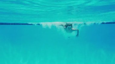 Havuzda yüzen çocuk. Su altında yüzme eğlencesi. Çocuk havuz başında eğleniyor. Aktif çocuk yüzücü. Yaz havuzu aktiviteleri. Havuzda yüzen oyuncu çocuk. Çocuk suya su sıçratıyor. Eğlenceli çocuk su altında yüzüyor.