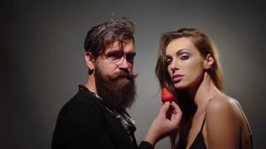 Seksi çift çilek yer. Çilek yiyen seksi kadın ve erkek. Şehvetli meyve. Çilek yalayan mankenler. Kışkırtıcı bir çift. Seksi baştan çıkarıcı ısırık. Bir çift çilek yalıyor. Arzu ve tutku