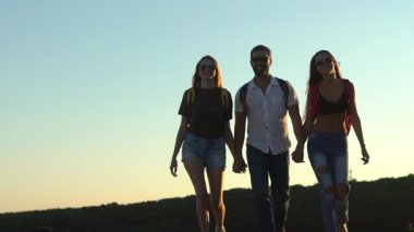 Arkadaşlar birlikte yürüyor. Bir grup turist seyahat ediyor. Seyahate çıkmış arkadaşlar. Arkadaşlarla açık hava macerası. Arkadaş yürürken keşfe çıkıyor. Bir grup arkadaş dışarıda yürüyor.
