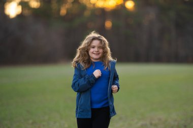 Hareketli çocuk, enerji dolu. Koşan çocuklar gün ışığında oynuyorlar. Neşeli koşucu dışarıda egzersiz yapıyor. Küçük koşucu, koşmanın eğlencesi. Çimenli bir arazide yarışan çocuk