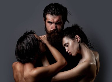 Şehvetli üçlü öpücük. Samimi ilişki ve cinsel ilişki. Tutku ve şehvet. Aşık çift. Romantik ve aşk dolu. Üçlü konsept. Üç seksi model birlikte. Bir erkek ve iki seksi kadın.