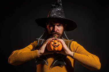 Cadılar Bayramı balkabaklı komik bir model. Cadılar Bayramı şapkalı balkabaklı insan portresi. Şeker mi şaka mı? Cadılar Bayramı şapkalı korkunç hippi. Cadı şapkalı adam balkabağını tutuyor. Baba, mutlu ol.