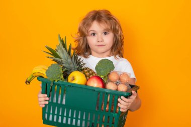 Marketten alışveriş sepeti alan bir çocuğun portresi. İndirim ve indirim. Komik çocuk suratı