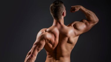 Erkeksi bir kavram. Karın kasları olan kaslı bir model. Şehvetli erkek vücudu. Seksi adam gururlu görünüyor. Latin aşığı. Tişörtsüz adam. Kaslı bir gövdenin şehvetli yakın çekimi. Erkek güzeli. Çıplak bir erkek vücudunun erotik sanatı