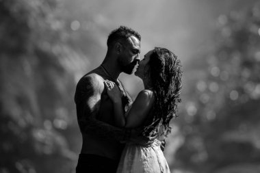 Şehvetli çift doğaya tutkuyla sarılıyordu. Doğayı öpen çiftler. Yaz doğasına aşık romantik çift. Seksi ve şehvetli bir çiftin açık hava portresi. Şefkatli öpücük ve tutkulu dokunuş