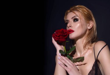 Romantik bir randevu ya da evlenme teklifi. Sıska, seksi, çıplak omuzlu, kırmızı güller tutan, stüdyo arka planında soyutlanmış bir kadın. Çiçekli şehvetli bir kızın portresi
