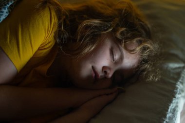 Çocuklar için yastık ve battaniye. Küçük çocuk uyuyor. Sevimli çocuk yatakta uyuyor. Uyuyan çocuk. Çocuk karanlık odada uyuyor. Evdeki bir yatakta uyuyan çocuk