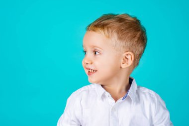 Gülümseyen güzel bir çocuğun portresi. Neşeli bir yüzü olan mutlu bir bebek. Yakın planda sevimli bebek yüzü. Neşeli bir gülümsemesi olan masum bir erkek bebek. Mutlu çocukluk portresi. Tatlı çocuk suratı.