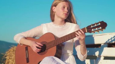 Gitar çalan kız. Gitarlı romantik bir kadın. Açık havada güzel bir şarkıcı. Yetenekli gitarist. Şehvetli bir müzisyen. Gitarlı nazik sarışın kadın. Müzik çalan sanatçı kadın. Kadın gitarist.