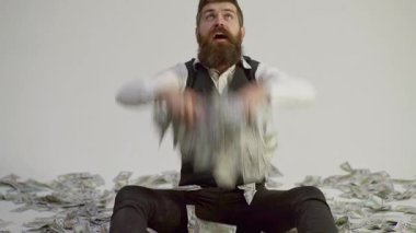 Zengin adam. Takım elbiseli bir işadamı, neredeyse sonbaharda para yağdıracak. Zengin İşadamı dolar banknotları içinde oturuyor. Nakit parası olan zengin bir adam. Dolar olarak çok parası olan zengin bir adam.