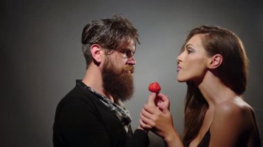 Seksi çift çilek yer. Çilek yiyen seksi kadın ve erkek. Şehvetli meyve. Çilek yalayan mankenler. Kışkırtıcı bir çift. Seksi baştan çıkarıcı ısırık. Bir çift çilek yalıyor. Arzu ve tutku