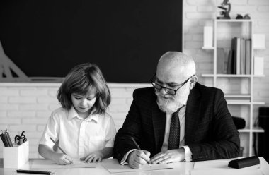 Öğretmen ve çocuk okulda birlikte öğreniyorlar. Eğitim. Çocuk adaptasyonu