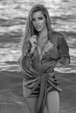 Beautiful girl enjoying sunbath at beach. Sensual young tanned woman enjoying breeze at seaside. Natural sexy boobs, women body shape, sexy breast. Bra model