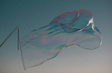 Gökkuşağı yansımalı sabun köpükleri. Mavi gökyüzünde kabarcıklar. Baloncuk partisi