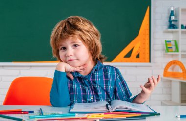 Okul çocukları yeşil karatahtaya karşı. Çocuk okula hazırlanıyor. Sınıfta Şirin Anaokulu