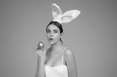 Easter bunny girl wear easter fluffy bunny ears hold easter eggs, isolated studio background. Eater portrait of female bunny