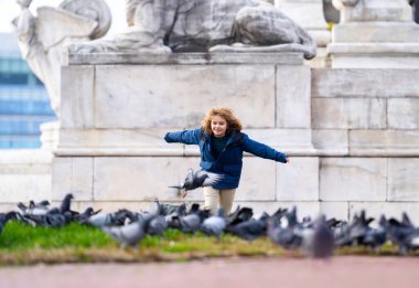 Happy child chasing birds on autumn day. Child run for pigeons. Carefree kids concept. Happy childhood. A Happy child chases pigeons in park. Happy Child playing with doves. Carefree Kid run pigeons clipart