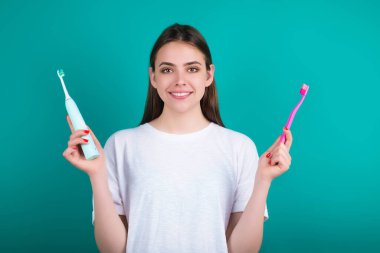 Diş fırçası ve diş macunu olan genç bir kadın. Dişçilik için stüdyo kadın portresi. Diş macunu konsepti. Diş bakımı. Ağız ve dişler. Diş macunuyla fırçalayan genç kız dişleri. Beyazlatma