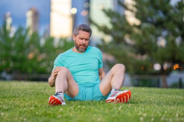 Antrenmandan sonra dizim kırıldı. Koşu sırasında bacağım ağrıyor. Dizini tutan yaralı bir adam. Koştuktan sonra bacakları ağrıyor. Dizinden yaralanan bir adam. Antrenman bacak ağrısı. Koşu diz travmasına yol açıyor. Bacak ağrısı.