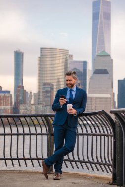 New York 'ta iş. Açık havada akıllı telefon kullanan bir iş adamı. Takım elbiseli bir iş adamı, Manhattan, New York 'taki uygulamalı mesajla cep telefonu kullanıyor. İş konuşmaları. Akıllı telefonlu bir iş adamı.