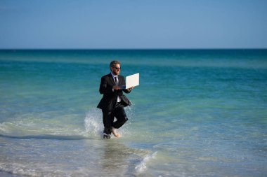 Boş bir hafta sonu ve uzak bir serbest çalışma. Denizde koşan takım elbiseli çılgın komedyen. Suyun üstünde dizüstü bilgisayarı olan komik bir iş adamı. Uzak bir yaz işi. İş adamları için yaz tatili