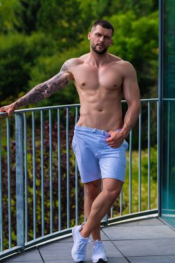 Spor salonunda egzersiz yapan güçlü bir genç adam. Spor kulübünde spor erkek antrenmanı. Genç adamın fitness antrenmanı var. Erkek sporcu egzersiz, spor ve antrenman yapar. İnsanlar spor ve sağlıklı yaşam tarzları