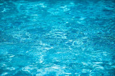 Su arka planı, dalgalanma dalgaları. Mavi yüzme havuzu deseni. Deniz yüzeyi. Yüzme havuzunda su ve güneş yansıması. Kopyalama alanı olan pankart