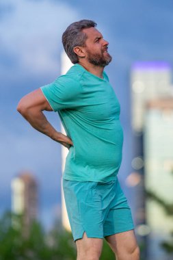 Sırt ağrısı çeken olgun bir sporcu. Ağrıyan kaslarda sorun var. Spor ağrı kesicisi. Koştuktan sonra omurga ağrısı. Antrenmandan sonra kas gerilimi. Sırtında ağrı var. Sırt ağrısı