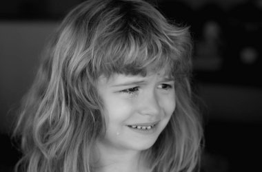 Ağlayan bir çocuğun portresi. Ağlayan bir çocuk. Acı içinde ağlayan bir duygu. Yanağına gözyaşı damlıyor.