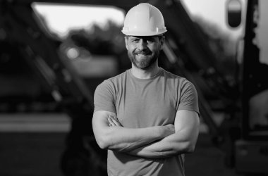 Builder with excavator for construction at the construction site. Machinery tractor with builder at building. Excavator tractor and builder worker. Builder in helmet on construction site