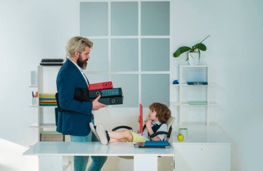 İşadamı babası ve oğlu ofiste iş evraklarını hazırlıyorlar. Gelecekteki kariyerim. İş arkadaşları konuşmada beyin fırtınası yapıyor