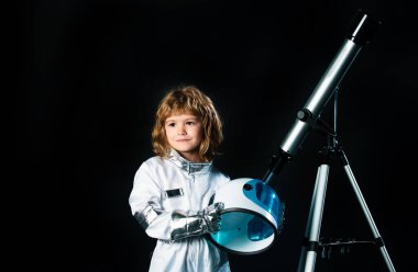 Küçük çocuk uzayda uçmak istiyor, teleskoplu çocuk astronot kaskı takıyor. Uzayı kopyala Başarı, yaratıcılık ve başlangıç konsepti