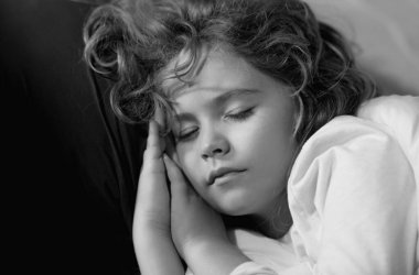 Little kid sleeps. Child sleeping on bed at home. Bedtime, kid sleeps. Child boy asleep on soft pillow with blanket