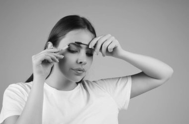 Koyu kaşlı güzel bir kadın kaş fırçası tutuyor. Kaş kaplaması. Güzellik prosedürlerini uygula. Kaş ve kaş çizgisi, kaş çizgisi.