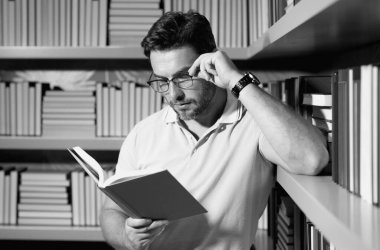 Kütüphanede kitap okuyan bir öğretmen. Öğretmenler günü, öğretmenler günü. Bilgi, eğitim. Kütüphanede ders veren bir öğretmen. Üniversite kütüphanesi. Öğretmenler edebiyat okuyor