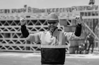 İnşaat alanında miğferli bir inşaatçı. İnşaat mühendisi üniformalı inşaat mühendisi. Yeni bir ev inşa etmeye hazır müteahhit portresi. İnşaat alanında inşaat işçisi