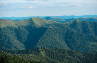 Dağ manzarası. Harika bir ilkbahar. Otlak arazisi ve yuvarlanan tepeler. Kırsal manzara