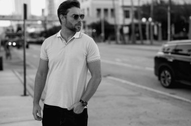 Büyük şehirde kendine güvenen yakışıklı bir adamın portresi. Sokakta poz veren sıradan giyinmiş seksi bir adam. Şehir yaşam tarzında başarılı bir erkek model. Kafkasyalı orta yaşlı adam dışarıda.