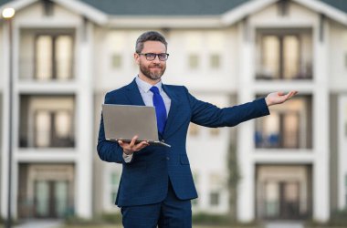 Dışarıda dizüstü bilgisayarda çalışan bir adam. Adam dizüstü bilgisayardaki e-postaları kontrol ediyor, sosyal ağda mesaj yazıyor, interneti kullanıyor, dışarıdaki bilgisayarlarda bilgi arıyor. Ev yakınlarında dizüstü bilgisayar kullanan bir adam.