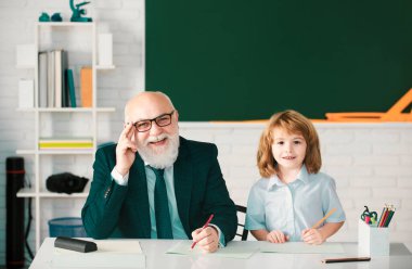 Okuldaki mutlu çocuk. Öğretmenin öğrenmesine yardım et. Eğitim, öğretmenlik, ilkokul