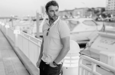 Sokakta polo tişörtlü yakışıklı bir genç. Dışarıda poz veren yakışıklı, kendine güvenen bir hippi modeli. Yatın yanında zengin bir adam hayal ediyor..