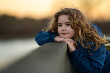 Çocuk yüzü. Bir çocuğun gözlerinde huzur ve ilham. Masumiyet ve mucize bir portrede yakalanır. Küçük hayalperest portresi. Açık havada çocukluk anı. Sarışın çocuk dışarıda huzurlu bir anın tadını çıkarıyor.