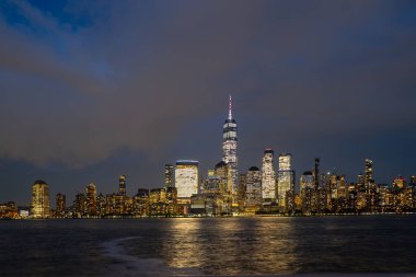New York City silueti. New York gökdelenleri. Manhattan gökdelenleri alacakaranlıkta. Işıklı New York manzarası. New York 'ta bir gece. NYC gece manzarası. Manhattan şehir merkezi. Alacakaranlıkta New York. Amerikan şehri