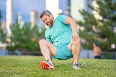 Koştuktan sonra diz ağrısı. Dizinden yaralanan bir adam. Egzersiz bacak ağrısına neden oluyor. Koşu diz travmasına yol açıyor. Açık hava egzersizi ve diz incinmesi. Şehir parkında koşudan kaynaklanan sağlık sorunları. Bacağım acıyor.