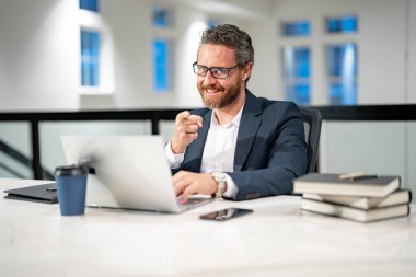 Ofis işyeri. Ofiste dizüstü bilgisayarla çalışan yakışıklı bir iş adamı. Klavyede daktilo yazan iş adamı, online iş toplantısı. Ofiste çalışan bir iş adamı. Bilgisayarı kullanan bir ofis çalışanı