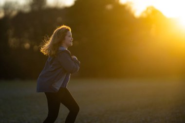 Hareketli çocuk, enerji dolu. Koşan çocuklar gün ışığında oynuyorlar. Neşeli koşucu dışarıda egzersiz yapıyor. Küçük koşucu, koşmanın eğlencesi. Çimenli bir arazide yarışan çocuk